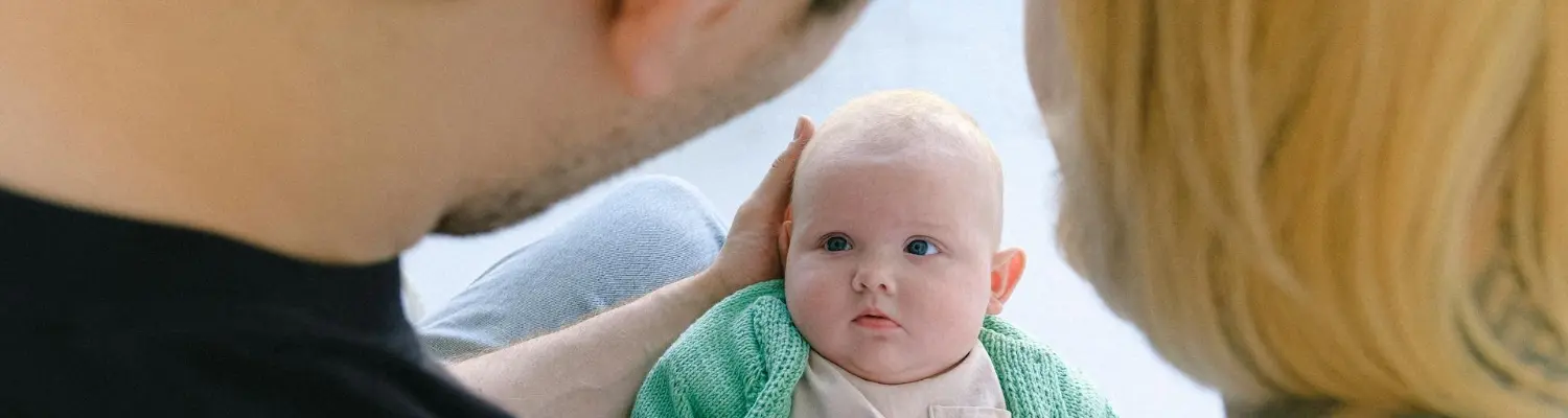 A couple holding and looking at their baby illustrating breastfeeding oxycodone connection