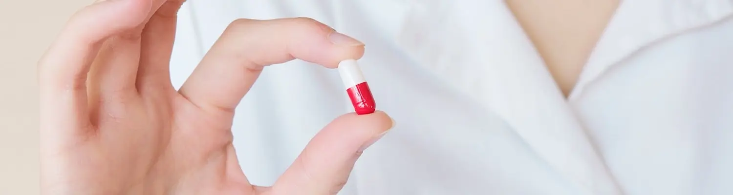 A doctor holding a pill