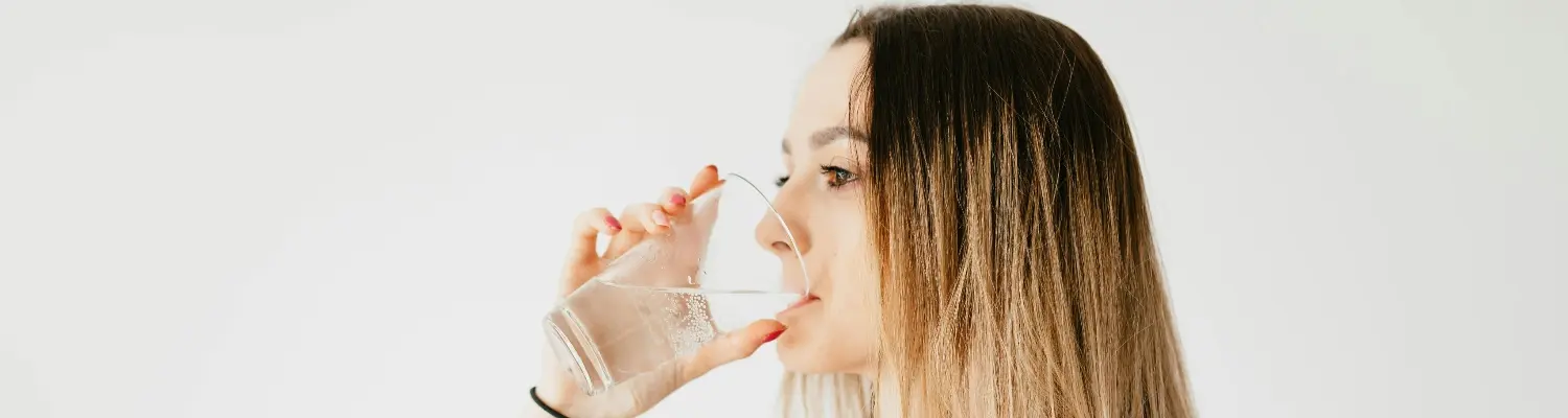 A person drinking water, which is how to get weed out of your system quickly