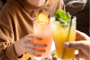 How to Stay Sober at a Party in New Jersey featured images with a person holding a nonalcoholic drink