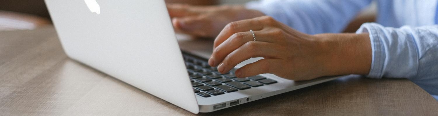 A person using a laptop, typing "detox centers near me"